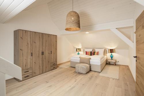 a bedroom with a white bed and a wooden floor at Centro 7 - Kristall Lungau in Tamsweg