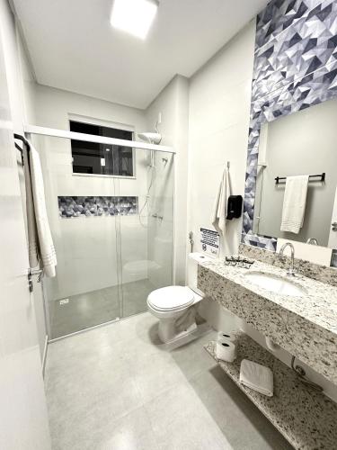 a bathroom with a shower and a toilet and a sink at Ecomarine Apart-hotel 800 m Beto Carrero in Penha