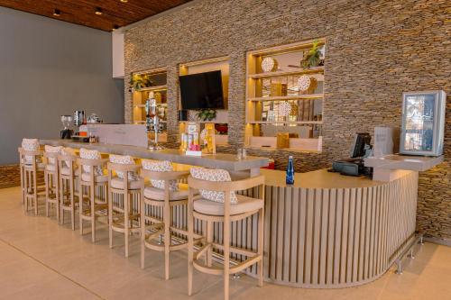 a bar with stools in a room with a brick wall at Apartamentos Luxury Frente al Mar - AR Rentals in Gaira