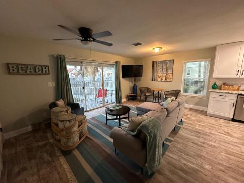a living room with a couch and chairs and a kitchen at Sunset Heaven in Navarre