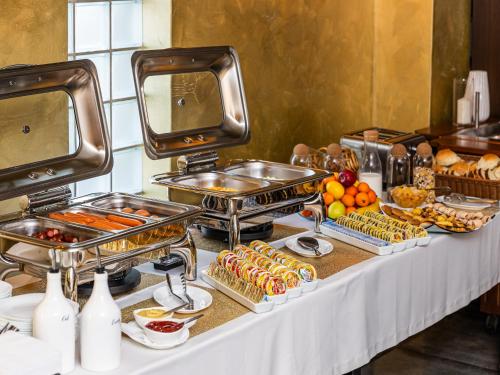 a buffet line with food on a table at Hotel Maxim in Arad