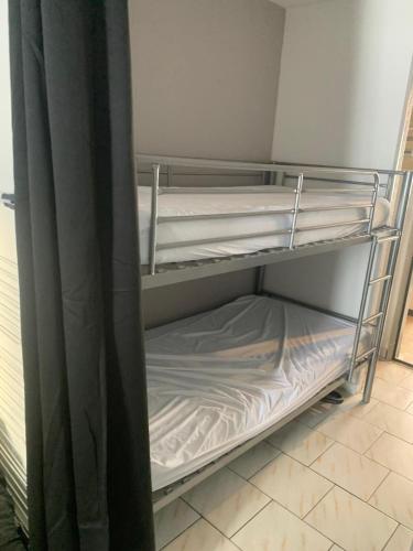 - un lit superposé vide dans une chambre à côté d'un rideau dans l'établissement Studio Club Engaly II - Valentine, à Aragnouet