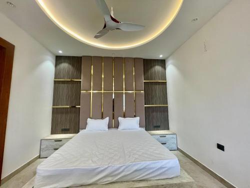 a bedroom with a large bed with a ceiling at Marine Ganga Stays in Rishīkesh