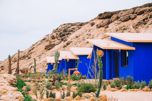 a blue building with a mountain in the background at Dakhla Attitude in Dakhla