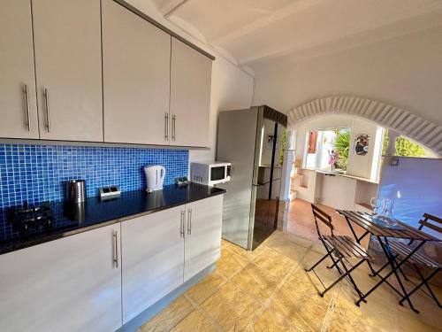 a kitchen with white cabinets and a table with chairs at Casa Mica in Albox
