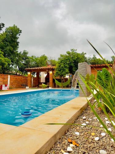 a swimming pool with a waterfall in a backyard at Quinta Tranquilandia in Piribebuy