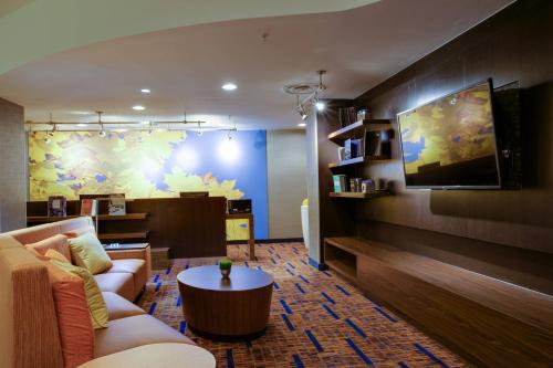 a living room with a couch and a tv at Courtyard Republic Airport Long Island/Farmingdale in Farmingdale
