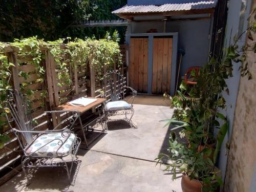 a patio with chairs and a table and a fence at CASA del PEZ céntrica para 5 huespedes in La Plata