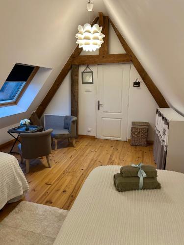 Cette chambre mansardée comprend un lit et une porte blanche. dans l'établissement Longère Normande, à Sainte-Marguerite