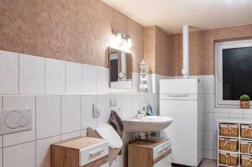 a small bathroom with a sink and a white refrigerator at Ferienhaus Hof Schäfer in Waldeck