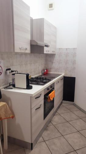 a kitchen with white cabinets and a stove top oven at Casa Manzoni in Novara