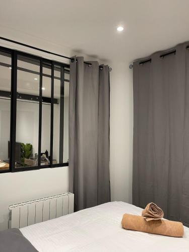 - un lit avec une serviette dans une chambre dans l'établissement L'Herbe ou ville, à Lyon