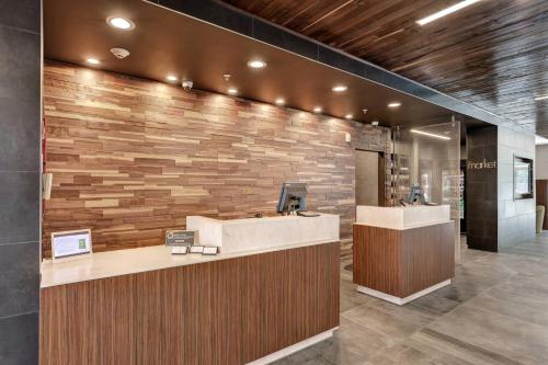 a lobby with a reception desk and a stone wall at Courtyard by Marriott Deptford in Almonesson
