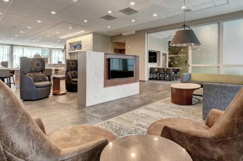 a lobby with chairs and a television in a building at Courtyard by Marriott Deptford in Almonesson