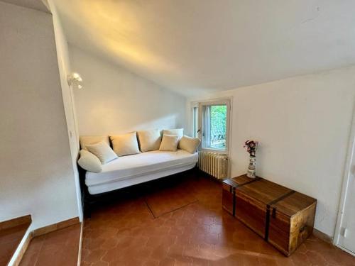 un salon avec un canapé blanc et une table dans l'établissement L'Orange, agréable gîte en pleine nature, à Hyères