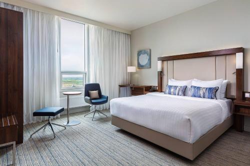 a hotel room with a bed and a desk and chair at Courtyard by Marriott Reykjavik Keflavik Airport in Keflavík