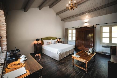 a bedroom with a bed and a desk and a table at Residenza San Vito in Calamandrana