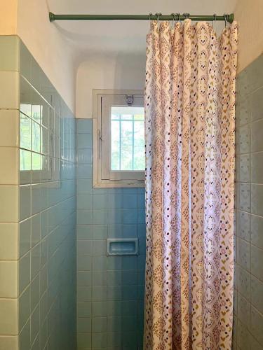 - un rideau de douche dans la salle de bains pourvue d'une fenêtre dans l'établissement L'Orange, agréable gîte en pleine nature, à Hyères