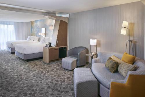 a large hotel room with a bed and a couch at Courtyard by Marriott Jackson in Jackson