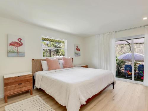 ein weißes Schlafzimmer mit einem Bett und einem Fenster in der Unterkunft Charming Two-King-bedroom house in delightful Naples in Naples