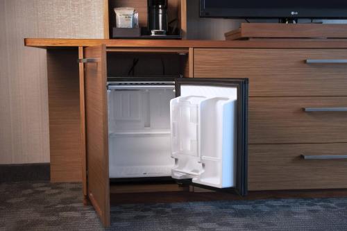 an open refrigerator sitting in a cabinet in a room at Courtyard by Marriott Philadelphia South at The Navy Yard in Philadelphia