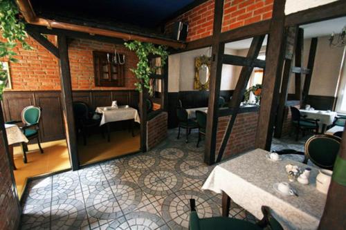 Blick auf ein Restaurant mit Tischen und Stühlen in der Unterkunft Pension Ikar in Schwerin