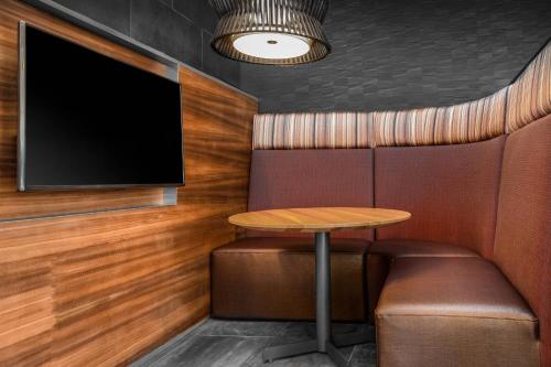 a dining room with a table and a tv at Courtyard by Marriott Jonesboro in Jonesboro
