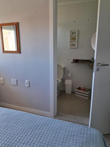 a bathroom with a toilet and a bed in a room at Apartamento novo entre a praia dos Ingleses e Santinho in Florianópolis