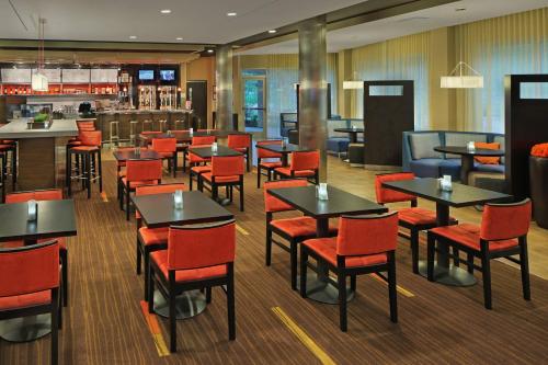 a restaurant with tables and chairs and a bar at Courtyard Philadelphia Coatesville Exton in Coatesville