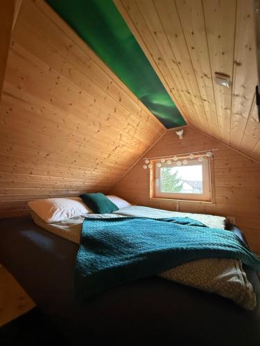 a bedroom with a bed in a wooden room at Islandzka chatka in Mżyki