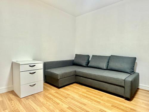 un canapé dans un salon avec une commode blanche dans l'établissement Modern studio near Gare de Lyon Bercy F1, à Paris