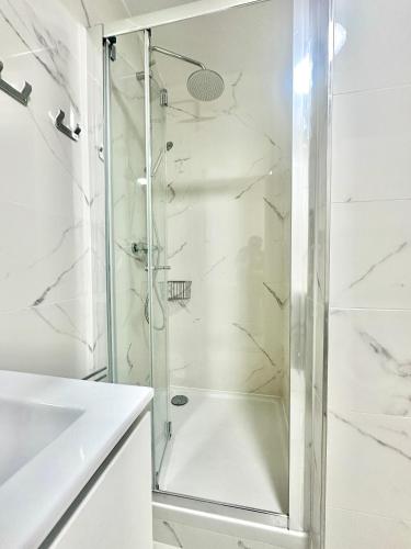 une douche avec une porte vitrée dans une salle de bain dans l'établissement Modern studio near Gare de Lyon Bercy F1, à Paris