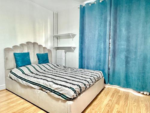 - une chambre avec un lit doté d'un rideau bleu dans l'établissement Modern studio near Gare de Lyon Bercy F1, à Paris