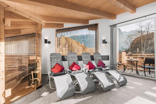 a room with four chairs with red pillows at See das Ferienhaus in Oetz