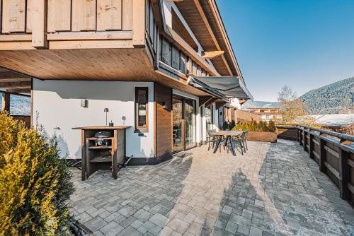 a patio of a house with a table and chairs at See das Ferienhaus in Oetz