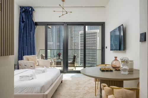 a living room with a bed and a table and a room with a view at Business Bay Studio Binghatti Canal with Terrace in Dubai