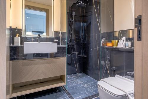 a bathroom with a shower and a sink and a toilet at Business Bay Studio Binghatti Canal with Terrace in Dubai