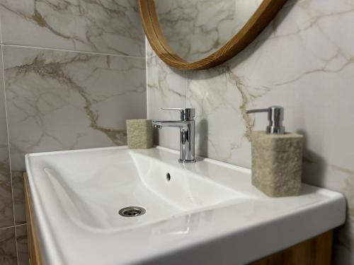 a white sink in a bathroom with a mirror at Eco Sadyba Chertizh in Tatariv