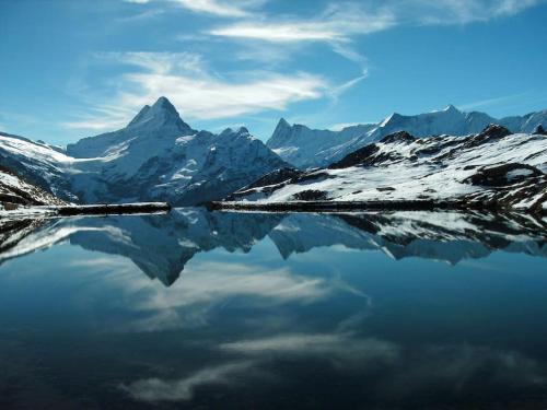a reflection of a mountain in a body of water at Chalet Heimat in Grindelwald