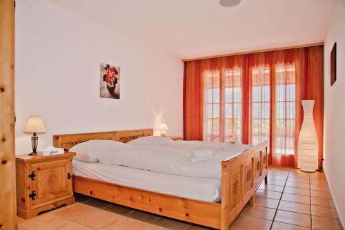 a bedroom with a large wooden bed and a window at Chalet Heimat in Grindelwald
