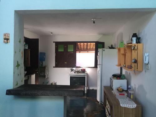 een keuken met een witte koelkast en een raam bij Casa Laranja in Arraial d'Ajuda