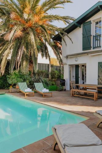 une maison avec un palmier et une piscine dans l'établissement Villa Bayard - Biarritz, à Biarritz