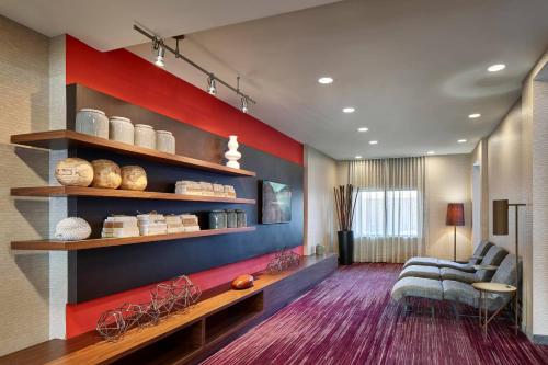 a living room with a couch and shelves with ceramics at Courtyard Philadelphia/Langhorne in Langhorne