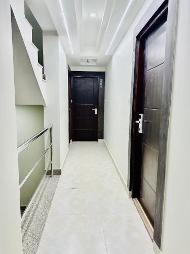 a hallway with a black door and a staircase at Airport Budget Hotel in Pashupatināth