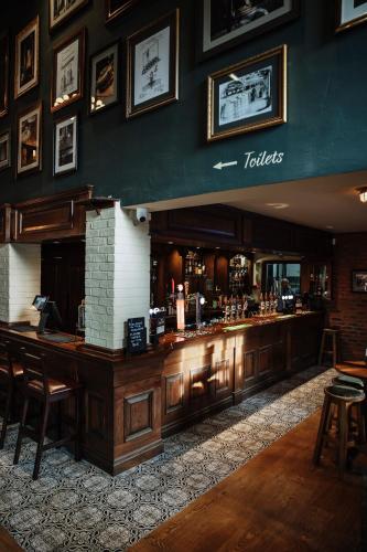 a bar in a restaurant with wooden tables and chairs at The Keelman in Newcastle upon Tyne