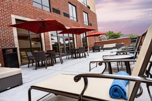 an outdoor patio with tables and chairs and umbrellas at Courtyard Winston-Salem Downtown in Winston-Salem
