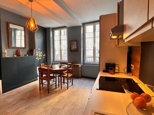a kitchen and dining room with a table and chairs at Logis Decaens in Caen