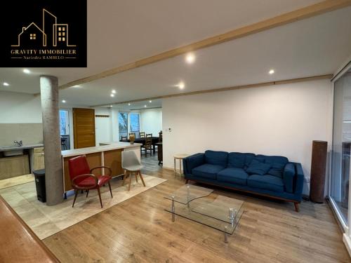 un salon avec un canapé bleu et une cuisine dans l'établissement Appartement 6pers - Marignier, à Marignier