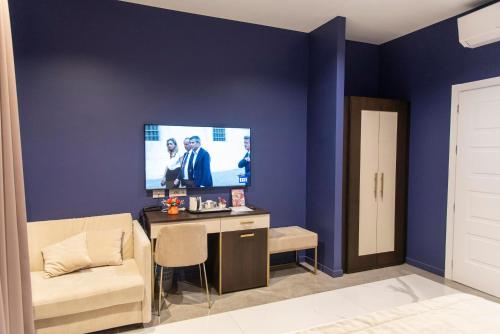 a living room with a tv on a blue wall at Adelaide Suite Dreams in Rome