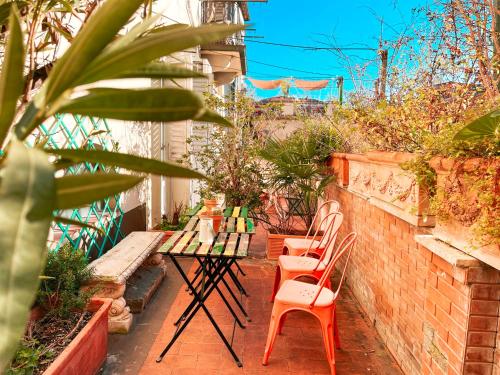 a patio with chairs and tables and a brick wall at Ostello Bello Firenze in Florence